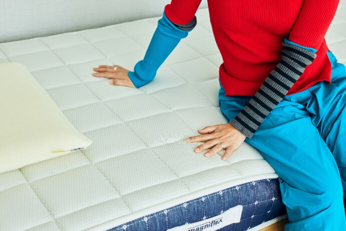 マニフレックスマットレスの肌触りを確かめている本多 り子さん